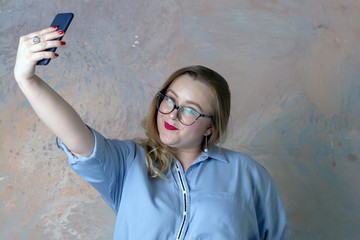 Canvas Print - The brown-haired girl makes selfie with the phone