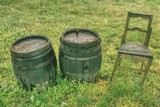 Fototapeta  - Dwie stare drewniane beczki i krzesło w ogrodzie winiarza