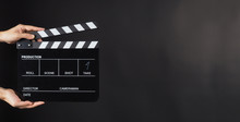 Hand Is Holding Black Clapperboard Or Movie Slate On Black Background.It Have Write In Number.