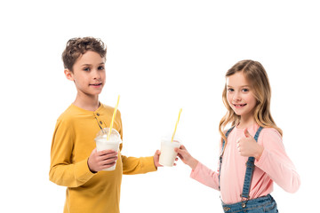 two kids holding milkshakes and showing thumb up isolated on white