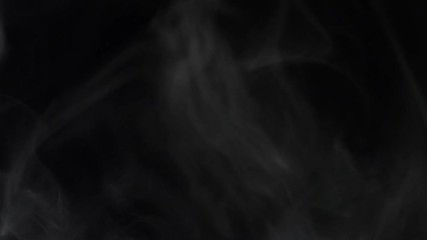 Poster - Mesmerizing close-up view of white puffs of smoke floating on the black background. Stock footage. Isolated on black