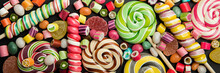 Panoramic Shot Of Bright Round And Swirl Lollipops Among Fruit Caramel Candies