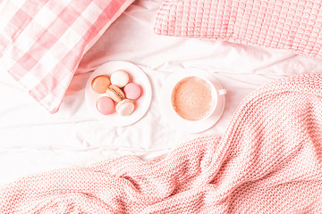 Wall Mural - Bed with pink knitted plaid, coffee and macaroons.