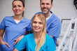 © gpointstudio - Team of smiling and satisfied dentists in dentist's office