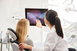 © gpointstudio - Rear view of dentist and patient looking at x-ray image