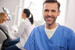 © gpointstudio - Front view of smiling male dentist in dentist's clinic