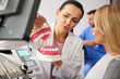 © gpointstudio - Dentist and young woman making a conversation in dentist's office