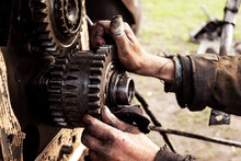 Man Repairs Engine Of Tractor, Agricultural Machinery. Bearing, Gears, Close-up.