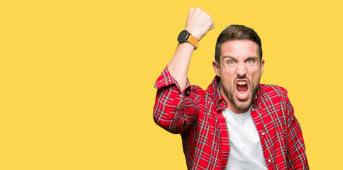 Sticker - Handsome man wearing casual shirt angry and mad raising fist frustrated and furious while shouting with anger. Rage and aggressive concept.