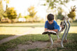 Giovane ragazzino sudamericano legge un libro sdraiato su una panchina nel parco sotto casa