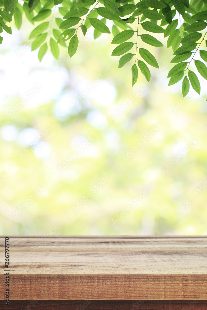 Wooden table and blurred green nature garden background. - obrazy, fototapety, plakaty 