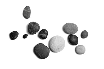 Wall Mural - Scattered sea pebbles. Smooth gray and black stones isolated on white background. Top view