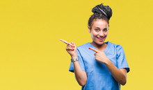 Young Braided Hair African American Girl Professional Nurse Over Isolated Background Smiling And Looking At The Camera Pointing With Two Hands And Fingers To The Side.