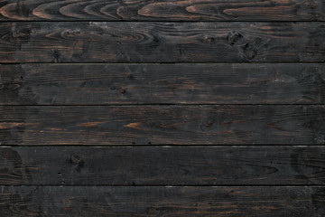 Horizontally arranged burnt boards. Black and brown wood texture.