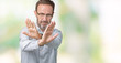 © Krakenimages.com - Handsome middle age elegant senior man wearing glasses over isolated background Rejection expression crossing arms and palms doing negative sign, angry face