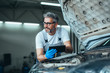 © cherryandbees - worker using tablet for car diagnostic service