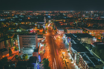 Aerial view of night city Voronezh downtown with illuminated buildings, malls, roads with car traffic, drone photo