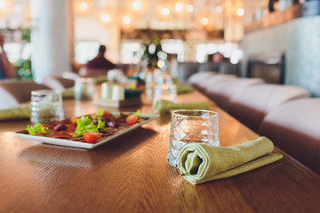 Two meat plate with salad leaves and summer salad in waiter's hand.