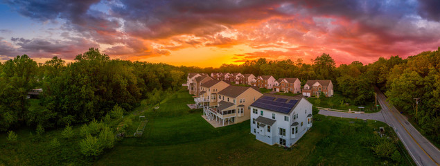 Modern American upper middle class single family homes neighborhood street with brick facade with solar panel in Columbia Maryland USA during sunset