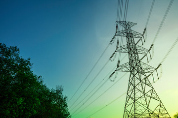 Electricity pole with silhouette sunset sky, Electricity pylon with shadow of tree in dawn time, Electricity power transmission line on sunset with copy space, Electricity pylon on orange sky