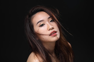 Young beautiful Asian woman makeup dark background 