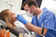 © gpointstudio - Focused stomatologist using dental drill and dental mirror
