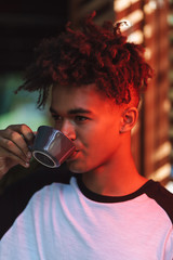 Sticker - Smiling african young man drinking coffee at the cafe