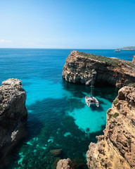 Lagoon with light blue water near island. Nature summer seascape in Malta. Travel and leisure in summer concept