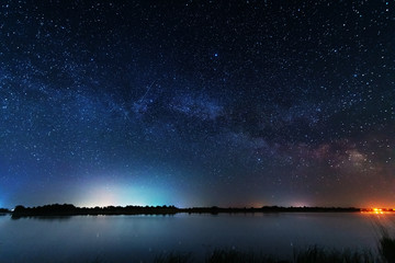 Wall Mural - magic starry night with the galaxy milky way near the river with a large tree.