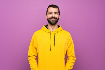 Handsome man with yellow sweatshirt laughing