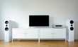 © lial88 - Modern audio stereo system with white speakers on bureau in modern interior