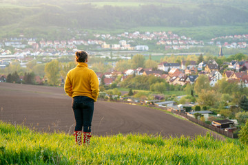 woman in a yellow jacket looking at jena in thuringia