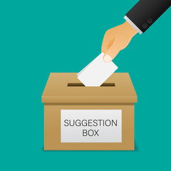 Hand putting paper in the suggestion box.