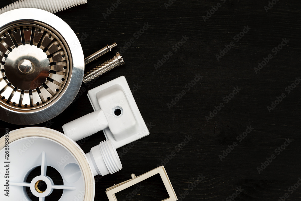 Drain Items Parts of sink drain items kit on a black background, text space, top ...