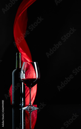  Fototapeta wino   lampka-i-butelka-czerwonego-wina-na-czarnym-tle-odbijajacych-swiatlo