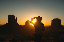 USA, Utah, Monument Valley, Silhouette Of Woman With Cowboy Hat Watching Sunrise