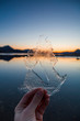 © Westend61 - Norway, Lofoten Islands, man's hand holding thin ice