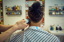 Crop View From Behind Of Anonymous Hairstylist Doing A Modern Haircut With A Razor To A Faceless African-american Customer