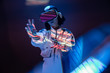 © Manuel Ruiz/ADDICTIVE STOCK - Excited young woman touching air while having virtual reality experience in neon light