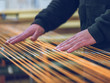 © PHILIPPE DEGROOTE/ADDICTIVE STOCK - Anonymous worker touching orange cotton threads on weaver loom on factory