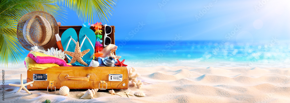 Full Suitcase With Accessories On Tropical Beach - obrazy, fototapety, plakaty 