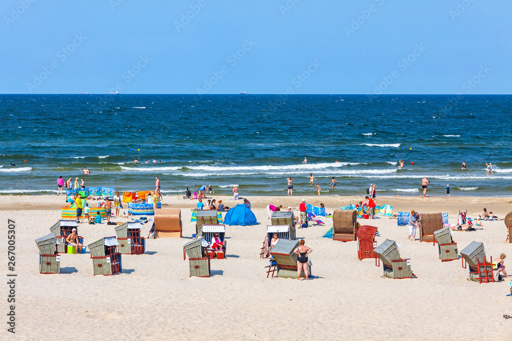 Unrecognisable people relax on a Baltic sea beach on Usedom island in Swinoujscie city, Poland - obrazy, fototapety, plakaty 