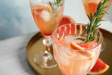 Glass of grapefruit cocktail on table, closeup. Space for text