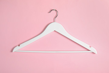 Empty clothes hanger on color background. Wardrobe accessory