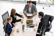© InfiniteFlow - Businessman executive in group meeting discussion with other businessmen and businesswomen in modern office with coffee cups and documents on table. People corporate business working team concept.