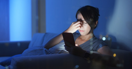 Wall Mural - Woman rubs tired eyes after using cellphone for a long time