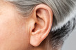 hearing, body part and old age concept - close up of senior woman ear