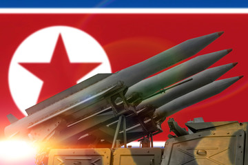 Nuclear missiles on the background of the North Korean flag. Threat of use of nuclear weapons.