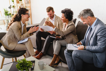 Wall Mural - Business people having informal meeting in office. Diverse team discussing work.