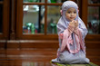 © Asada - Muslim kid girl wearing Hijab praying Dua during Ramadan period. The concept is Islam,Dua,religion,worship and sin.